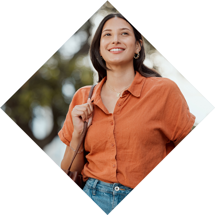 Woman in orange shirt smiling holding a work bag Woman in orange shirt smiling holding a work bag
