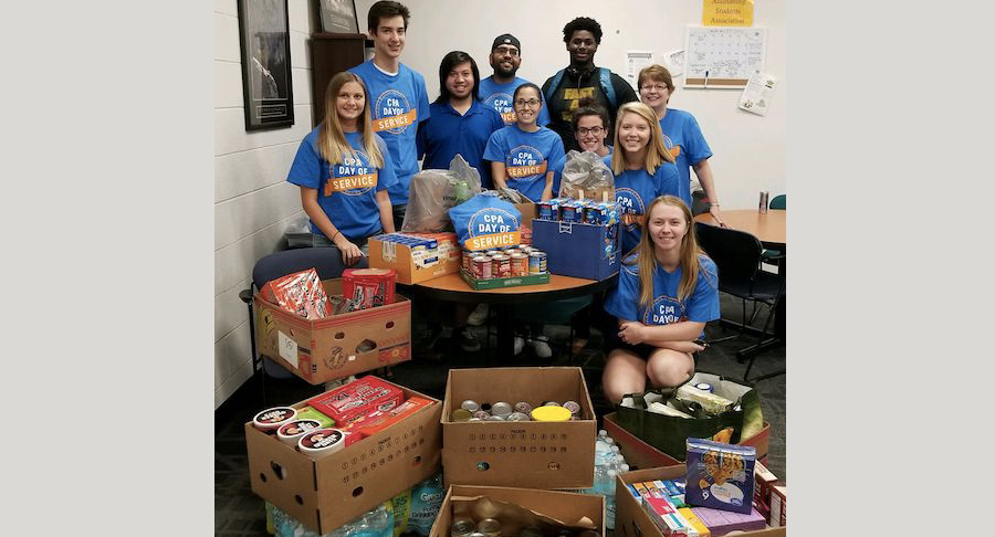 Students pose with boxes of canned goods