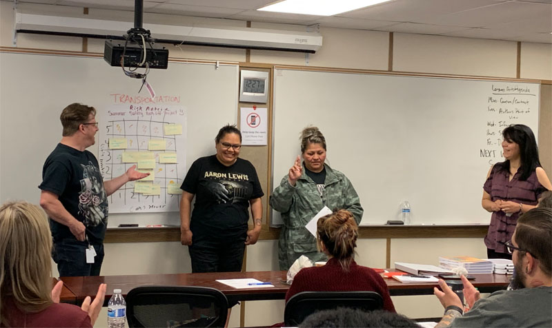 Four Native American students take part in a small group presentation as part of their community-based projects at the Muckleshoot Tribal College during the 2019 certificate program.