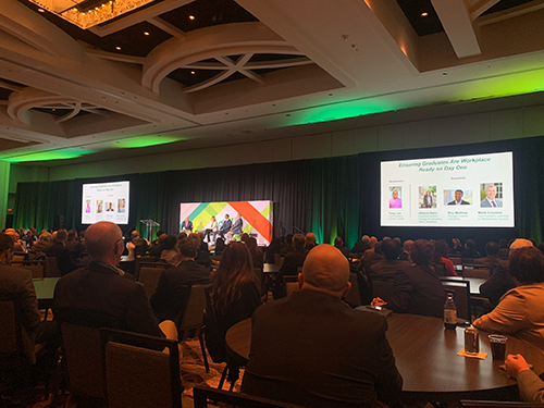 conference attendees watch presentation in large hall