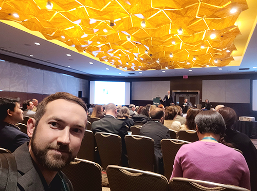 Selfie photo of Michael R Kowalski in foreground with session of attendees in background at AACSB's ICAM 2023