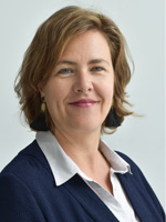Stephanie Villemagne of ESSCA. She has a light complexion and sandy brown chin-length hair side parted, with blue eyes and dark brows, and a closed-but-friendly smile and a dimple on her left cheek. She wears a dark blue suit jacket over a white collared shirt and gold and blue drop earrings and stands in front of a white background.