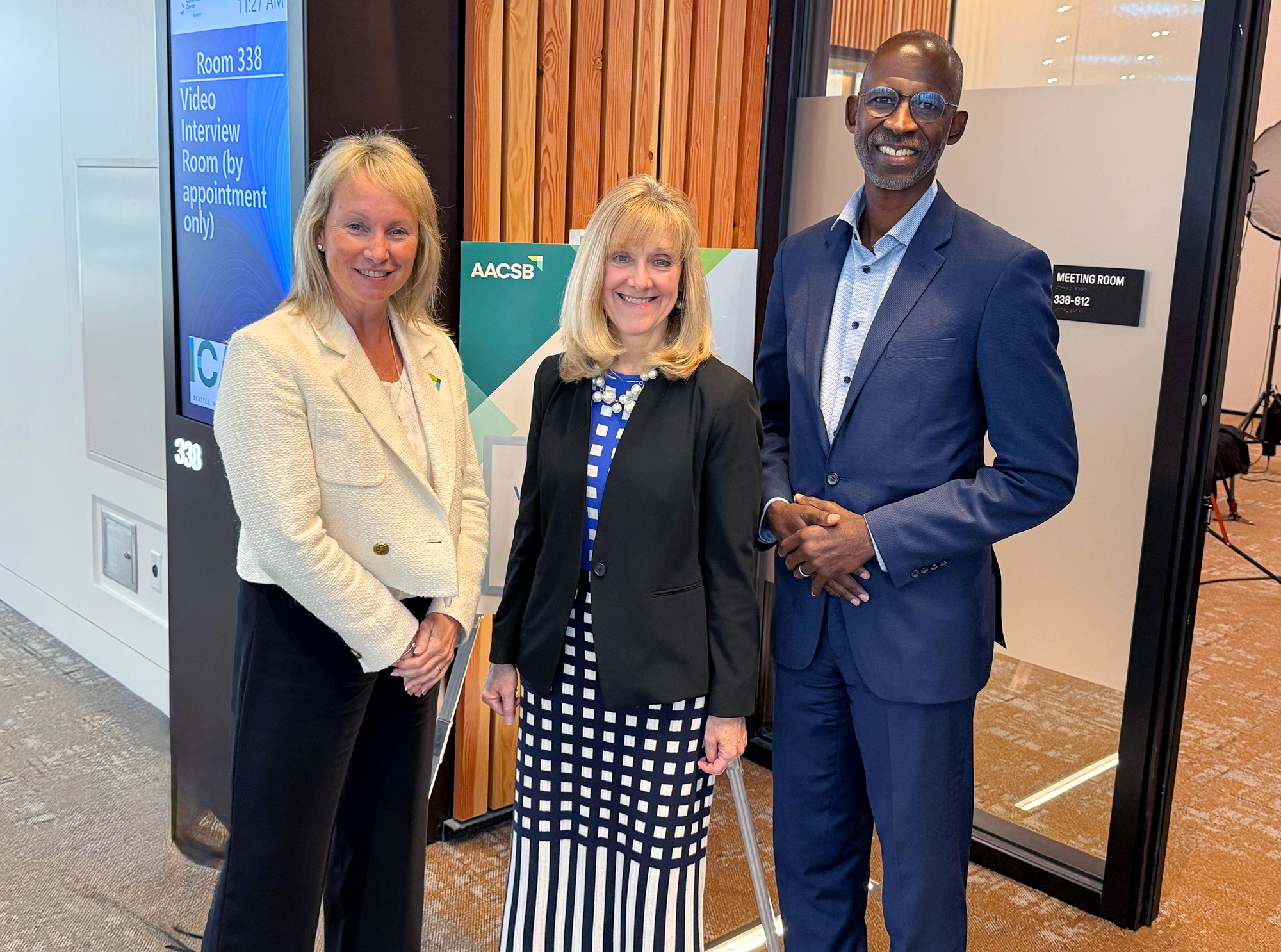Eileen McAuliffe, Joyce Strawser, and Ian Williamson standing together outside a meeting room at the Seattle Convention Center - Summit Building