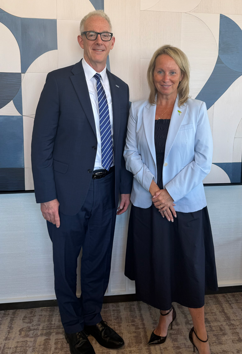 David Steingard and Eileen McAuliffe standing together in a hallway with abstract art in the background