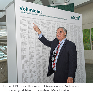 Barry O'Brien standing in front of volunteer wall at ICAM 2018